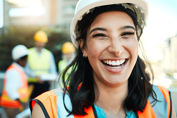 A woman in a construction hat smiling