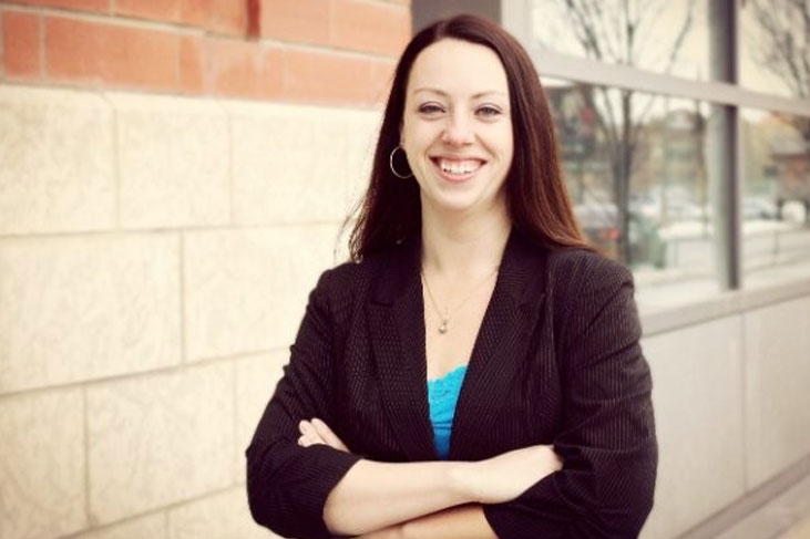 A woman in a blazer smiles at the camera